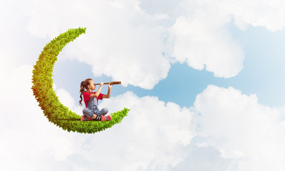 Concept of careless happy childhood with girl on green moon