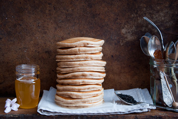 Homemade Whole Wheat Pancakes with honey on a brown wooden background  