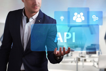 Business, Technology, Internet and network concept. Young businessman working on a virtual screen of the future and sees the inscription: API