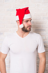 Guy with beard on serious face in red xmas hat