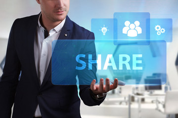 Business, Technology, Internet and network concept. Young businessman working on a virtual screen of the future and sees the inscription: Share