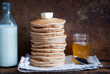 Homemade Whole Wheat Pancakes with honey on a brown wooden background  