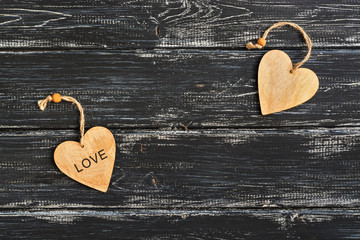 A wooden heart with the word love on a black wooden old background. Valentine's Day