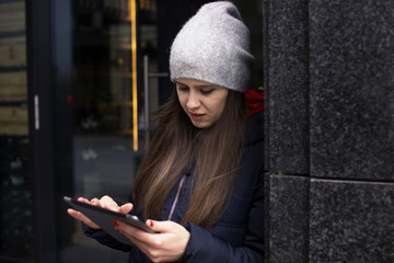a girl in a bright jacket stands near the wall