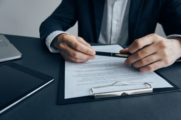 Business man on a light background checks documents at a desk in the office