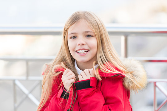 Child in red coat stand on bridge