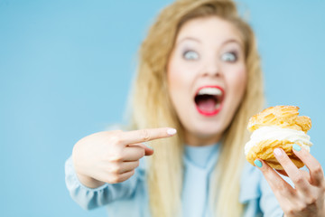 Funny woman holds cream puff cake