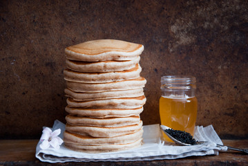 Homemade Whole Wheat Pancakes with honey on a brown wooden background  