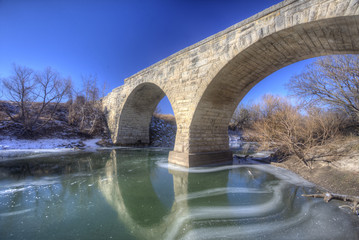 Clements Stone Arch Bridge over frozen stream, rural Kansas