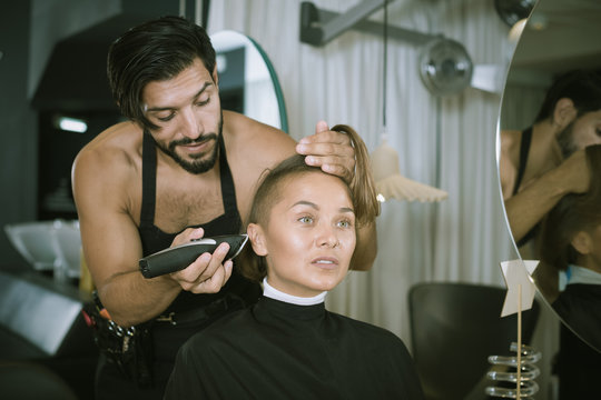 hairdresser with hair clipper with woman