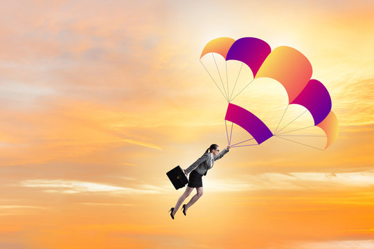 Businesswoman flying on parachute in business concept