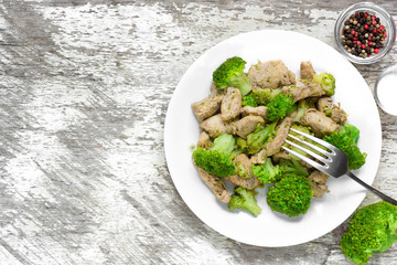 chicken fillet with broccoli in a plate with fork