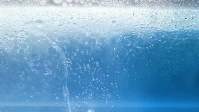 Foam with Bubbles and oil on blue background. Close Up Macro.