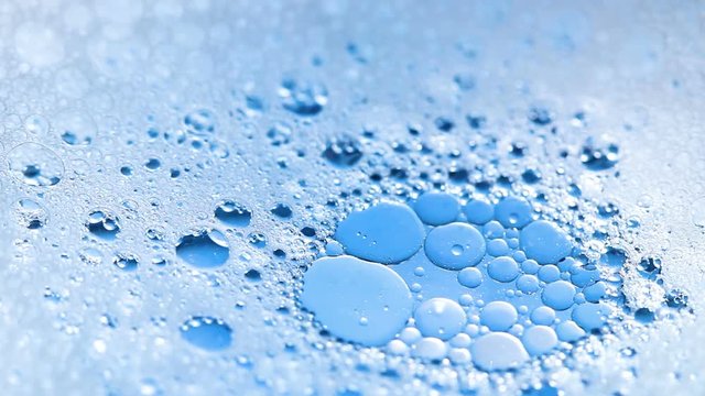 Foam with Bubbles and oil on blue background. Close Up Macro.
