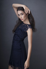 Female Model in navy blue evening lacy dress with fashion standing posing.