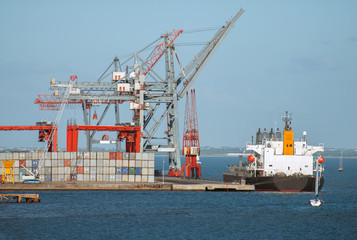 Industrial sea port with containers and cranes and ship.