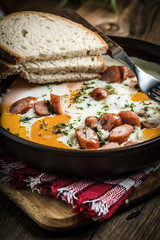 Tasty cooked egg with chopped sausages.