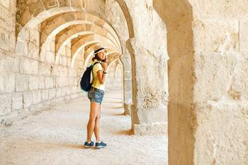 Fototapeta na wymiar Happy woman traveler exploring the ruins of the ancient Greek amphitheater Aspendos in Turkey