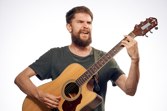 Man with beard playing guitar on white isolated background