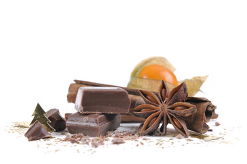 piece of chocolate, anise and cinnamon with physalis  on white background