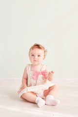 little girl is sitting in the studio and is playing