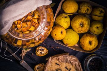 Ingredients tinctures Fruits twigs quince sugar cloves vanilla wooden table