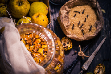 Ingredients tinctures Fruits twigs quince sugar cloves vanilla wooden table