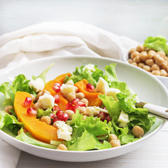 Fall pumpkin salad with chickpeas and cheese and pomegranate seeds
