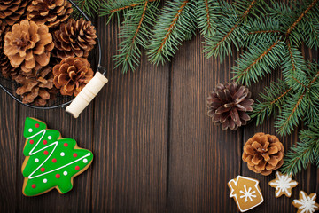 Christmas or New Year background. Fir-tree branches , Christmas tree toys, stars, snowflake and cones on dark brown wooden background. Selective focus. Top view. Copy space.