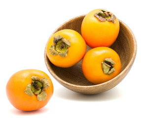 Persimmon Sharon in a wooden bowl isolated on white background.