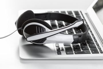 call center support concept. headset on keyboard computer laptop