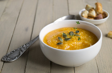 Vegetarian pumpkin soup on a wooden table.