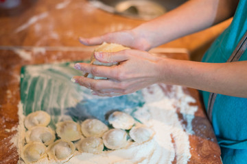 Female hands make home dumplings, close-up.