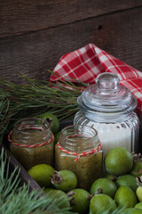 Winter Christmas Feijoa jam bottles with fruit and sugar on the rustic background