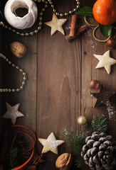 Christmas background. Cookies, sugar powder, nuts, spices, baking molds, fir-tree branch, pine cones on rustic background,  top view, copy space