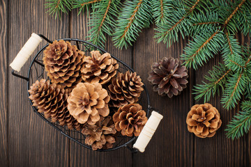Christmas or New Year background. Fir-tree branches , Christmas tree toys, stars, snowflake and cones on dark brown wooden background. Selective focus. Top view. Copy space.
