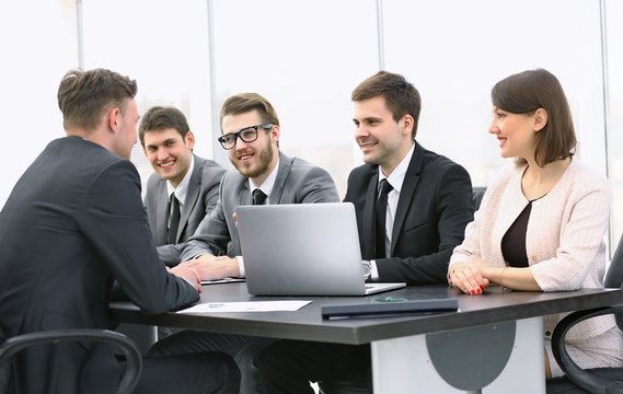 businessman talking to a business team at a Desk
