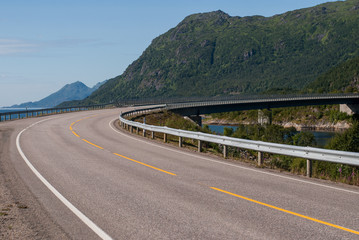 A steep curve of the road against the backdrop of the mountains
