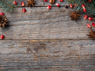 Pomegranate spruce branches star anise nuts, cinnamon and winter spices on wooden background, Rustic style Copy space