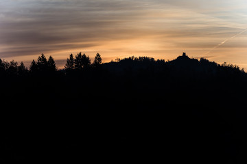 Old ruins on a forested mountain silhouetted