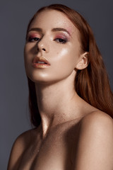 Beauty close up portrait of attractive woman with bright make-up at studio