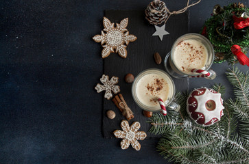 Eggnog, winter Christmas traditional hot drink with milk, eggs, rum. Christmass New Year decoration with gingerbread cookies.