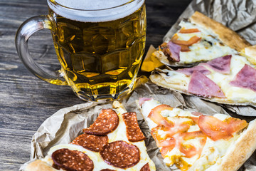 Light beer in glass and fragrant Italian pizza.