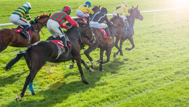 Race horses and jockeys racing towards the finish line with lens flare effect background