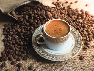 Espresso coffee Cup with beans on a burlap background.
