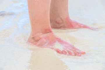 With bare feet on the beach