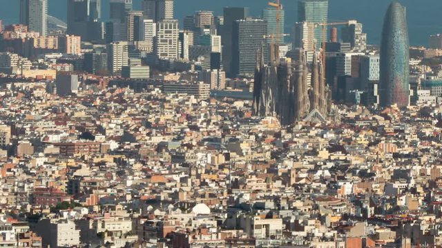 Barcelona downtown.The Big city with the "Sagrada Familia", the technological district  and the sea of background, and with the movement of shadows in buildings. Smooth camera movement: Tilt up.