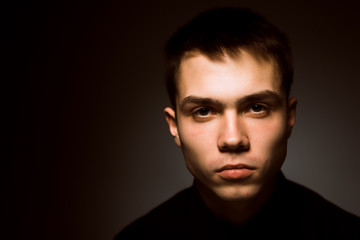 young guy on a dark studio background