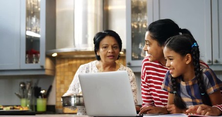 Multi-generation family using laptop in kitchen   - Powered by Adobe