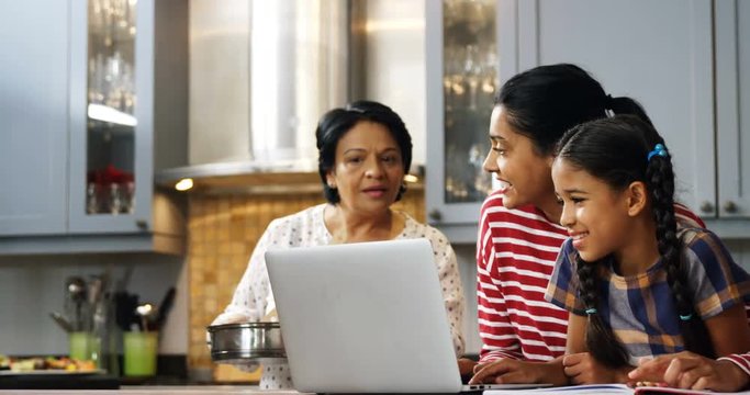 Multi-generation family using laptop in kitchen  